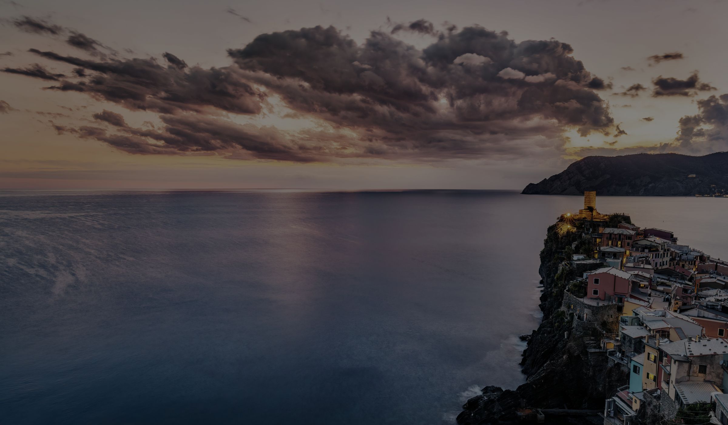Vernazza in den Cinque Terre bei Sonnenuntergang, die Häuser stehen auf einem Felsen über dem Meer